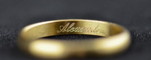Binnenring gravure van de naam Alexandra op een gouden trouwring